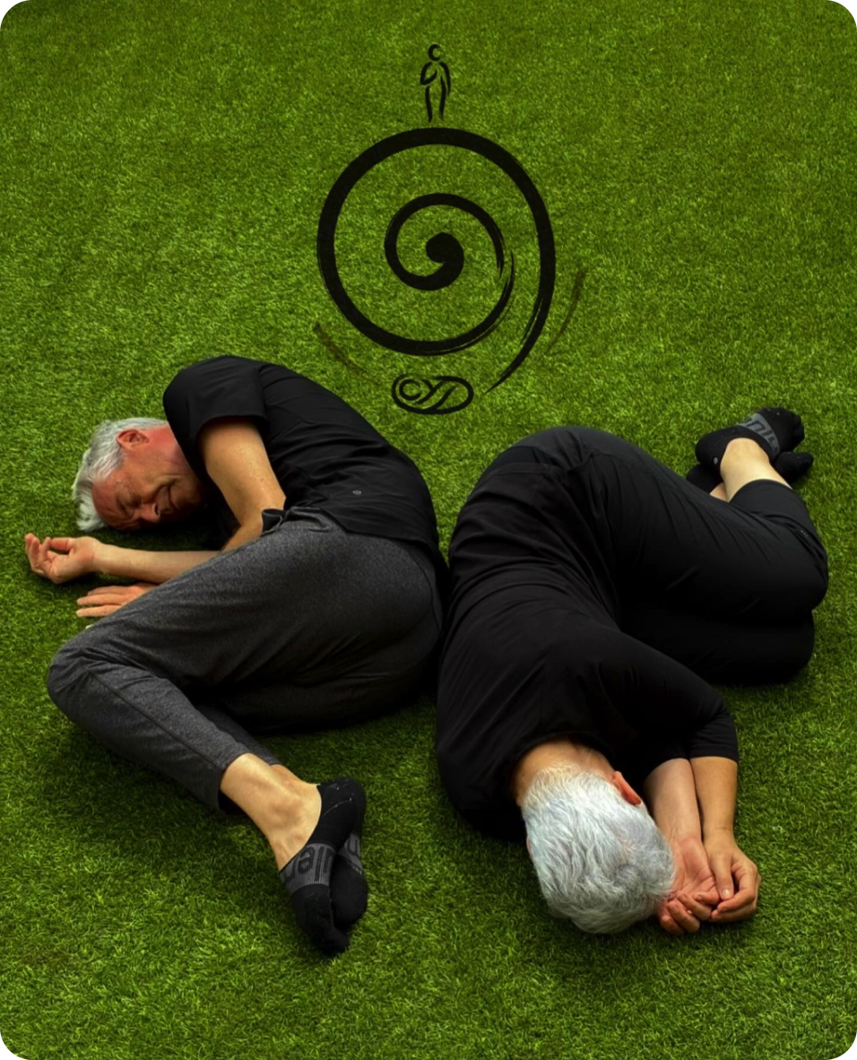 Christian et Adi en position fœtale au sol, vue de dessus, avec le symbole Manandah